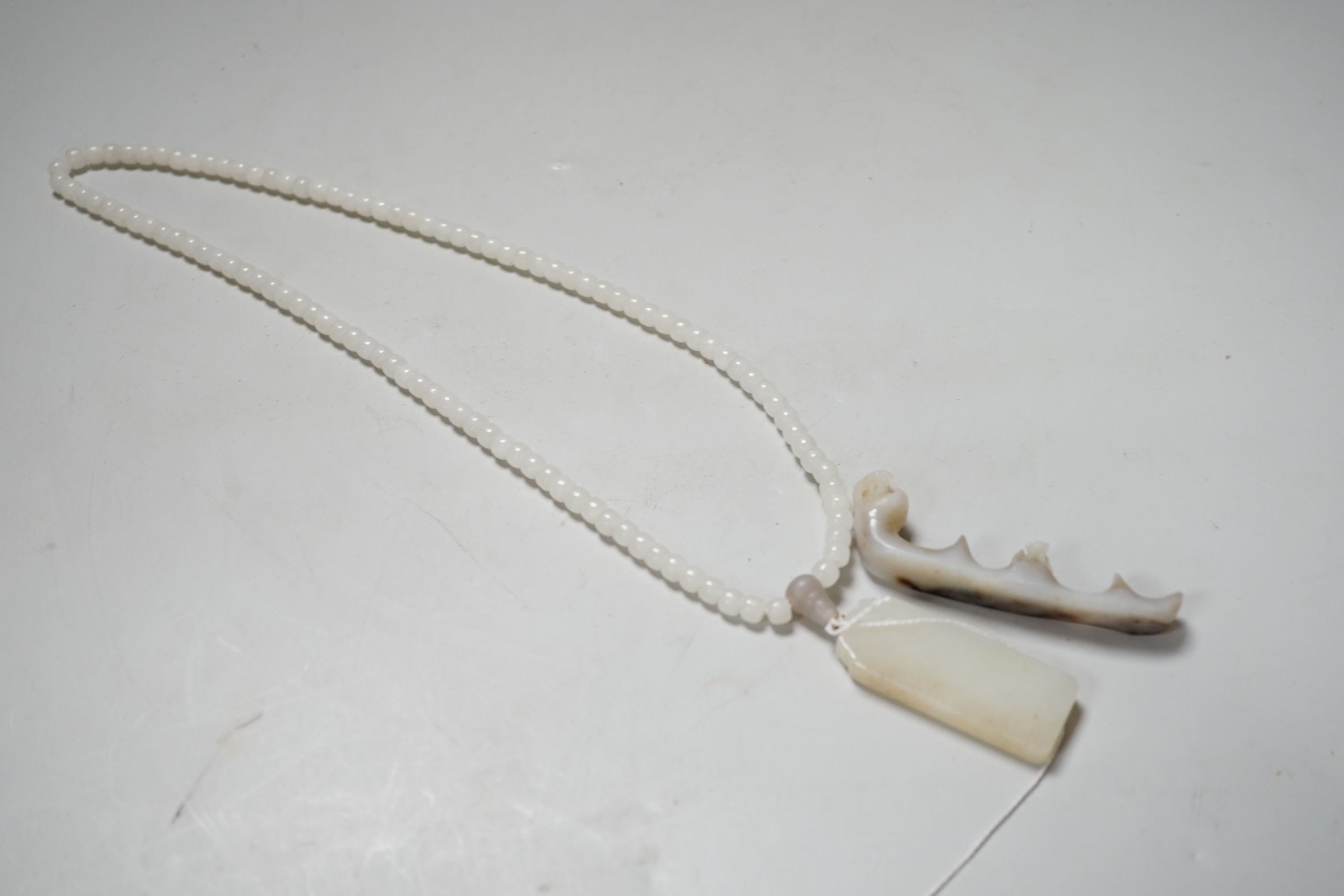 A Chinese white jade pendant and a jade brush rest